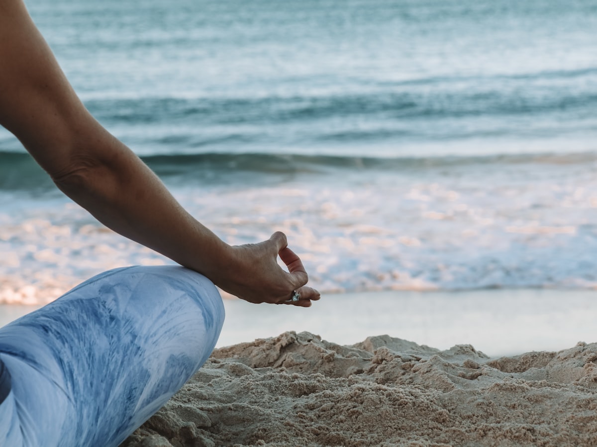 Hand in a calm mudra on the beach during mindfulness practice